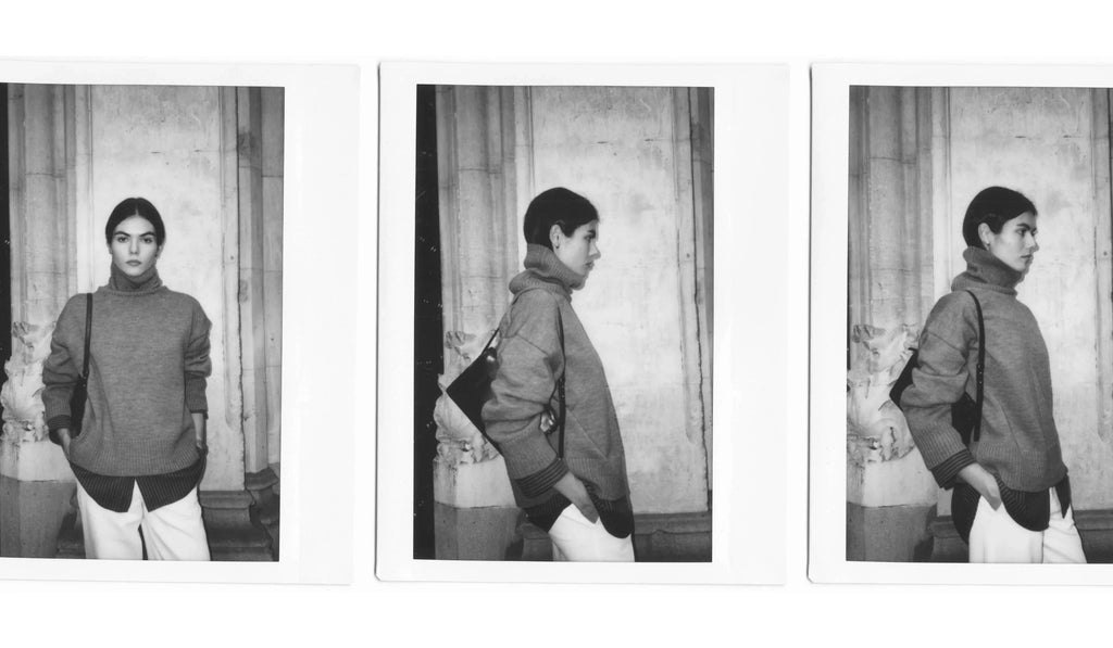 Black and white triptych of a woman modeling gray turtleneck sweater and white pants against stone wall