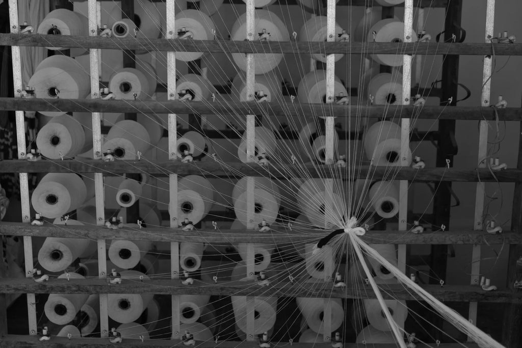 Industrial textile machine with multiple spools of thread in a weaving or spinning workshop